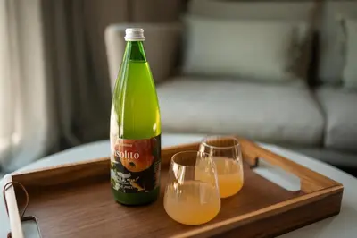 a green bottle and two glasses on a wooden tray at Agriturismo Insolito in Terlano