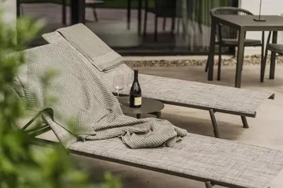 a chair with a book and a bottle of wine at Agriturismo Insolito in Terlano