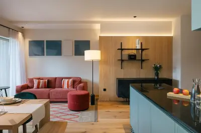 a kitchen and living room with a red couch at ANTON Nature Hideaway in Naz-Sciaves