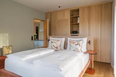 a bedroom with a large bed with white sheets and pillows at ANTON Nature Hideaway in Naz-Sciaves