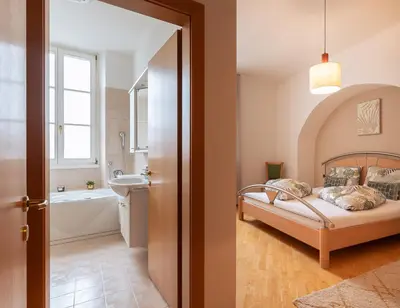 a bedroom with a bed and a tub and a sink at Apartment Perwanger in Appiano sulla Strada del Vino