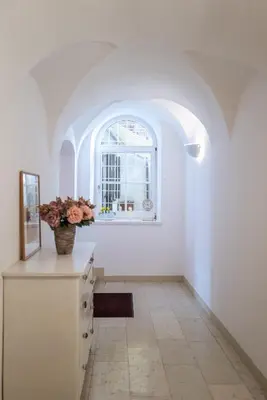 a room with a vase of flowers on a dresser at Apartment Perwanger in Appiano sulla Strada del Vino
