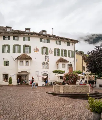 a large white building with black smoke in the background at Apartment Perwanger in Appiano sulla Strada del Vino