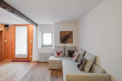 a living room with a couch and a bed at Ciasa de Sèn Jan in Pozza di Fassa