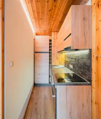 a kitchen with wooden walls and a wooden floor at Ciasa de Sèn Jan in Pozza di Fassa