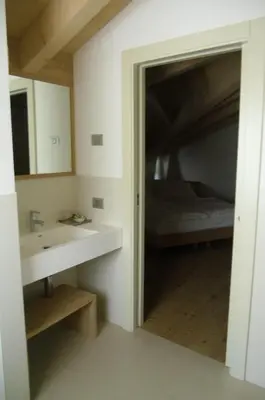 a bathroom with a mirror and a sink and a bed at Agriturismo Casa Preti in Revò