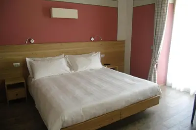 a bedroom with a white bed with a red wall at Agriturismo Casa Preti in Revò