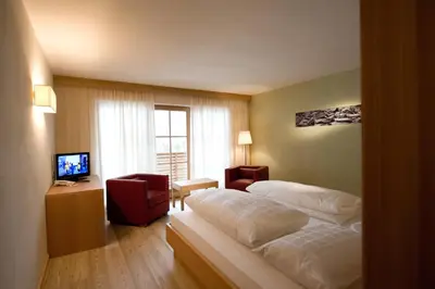 a hotel room with a bed and a television at Hotel Ostaria Posta in San Martino in Badia