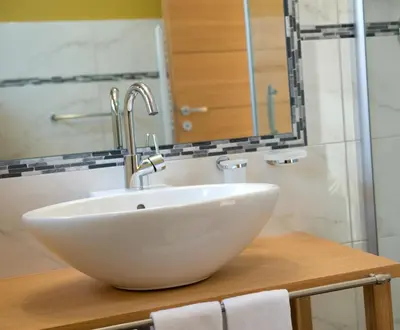 a bathroom with a white sink and a mirror at Hotel Ostaria Posta in San Martino in Badia