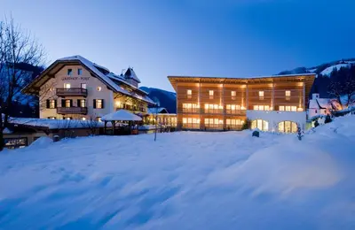 a large building in the snow in front at Hotel Ostaria Posta in San Martino in Badia