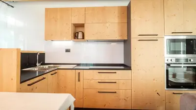 a kitchen with wooden cabinets and a stove top oven at Appartamento Vale e Schena Cortina 4 posti letto in San Vito di Cadore