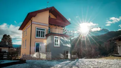 a house with the sun in the sky at Appartamento Vale e Schena Cortina 4 posti letto in San Vito di Cadore