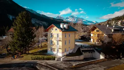 an aerial view of a house with mountains in the background at Appartamento Vale e Schena Cortina 4 posti letto in San Vito di Cadore