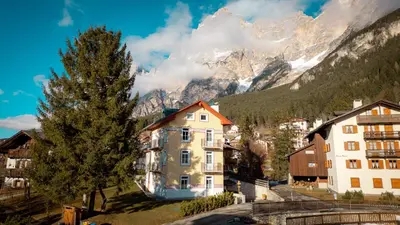 a town in front of a mountain with a house at Appartamento Vale e Schena Cortina 4 posti letto in San Vito di Cadore