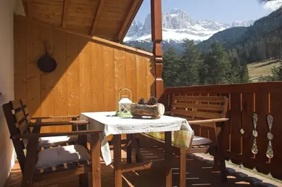 a table and chairs on a porch with a view at Apartments Dilln Gütl in Tires