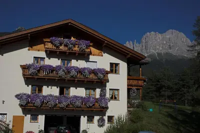 a building with purple flowers on the balconies at Apartments Dilln Gütl in Tires