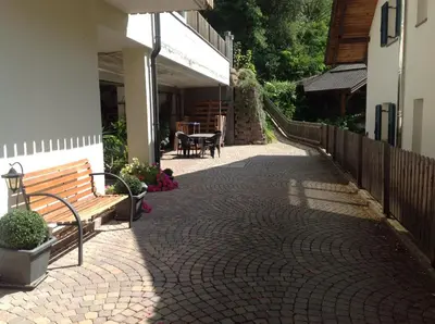 a brick walkway next to a building with a bench at Apartment Welscher in Nova Levante