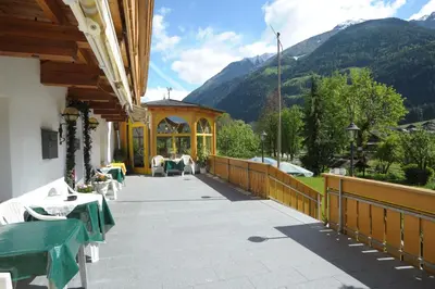 a patio with a gazebo with mountains in the background at Pension Peintner in Gais