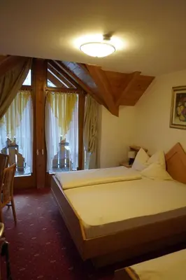 a bedroom with a bed and a large window at Pension Peintner in Gais
