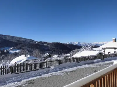 a fence covered in snow next to a house at Unterwirtshof in Nova Ponente