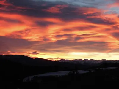 a sunset over a mountain range with mountains in the background at Unterwirtshof in Nova Ponente
