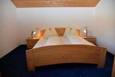 a bedroom with a large wooden bed with two lamps at Unterwirtshof in Nova Ponente