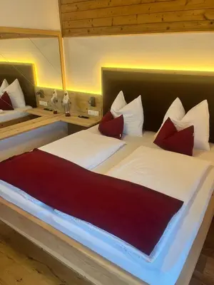 a bedroom with two beds with red and white pillows at Stroblhof in Vipiteno