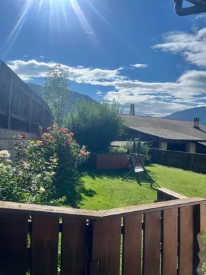 a backyard with a fence and a yard with flowers at Stroblhof in Vipiteno