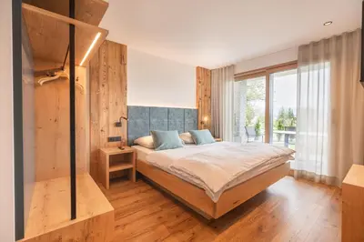 a bedroom with a bed and a large window at Linhea Apartments in Fiè