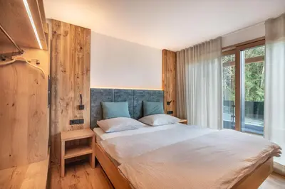 a bedroom with a large bed and a window at Linhea Apartments in Fiè