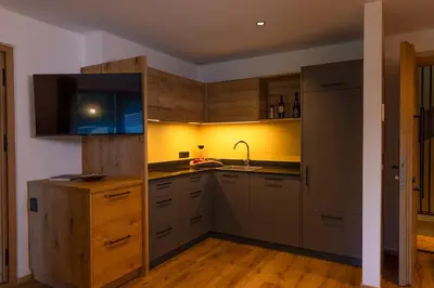 a kitchen with wooden cabinets and a sink in it at Linhea Apartments in Fiè