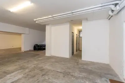 an empty room with white walls and concrete floors at Casa Alice in Falcade