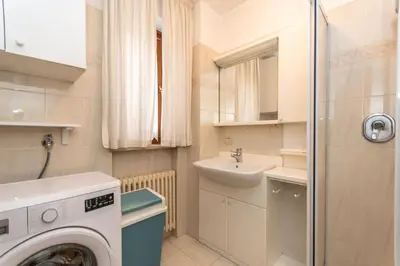 a small bathroom with a washing machine and a sink at Casa Alice in Falcade