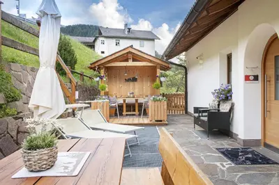 an outdoor patio with a table and chairs at Apartments Rondula Pic in Santa Cristina in Val Gardena