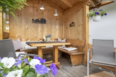 a wooden patio with a wooden table and chairs at Apartments Rondula Pic in Santa Cristina in Val Gardena