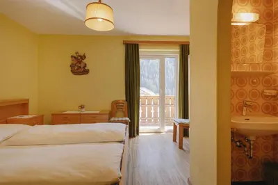 a hotel room with two beds and a sink at Apartments Martina in Selva