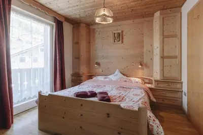 a bedroom with a bed and a large window at Apartments Martina in Selva