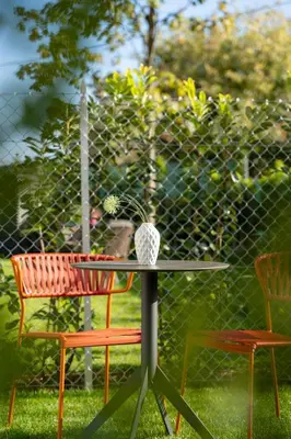 a table with two chairs and a vase on it at Apartments Villa Julia in Lana