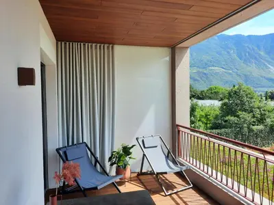 two chairs on a balcony with a view of a mountain at Apartments Villa Julia in Lana