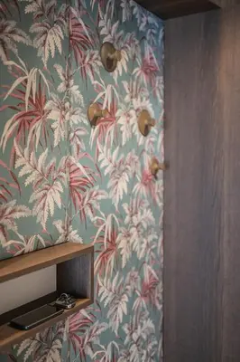 a bathroom with a wall with a floral wallpaper at Luis Chalet in Brunico
