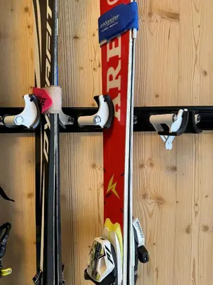 a group of skis and ski poles are hanging on a wall at Luis Chalet in Brunico