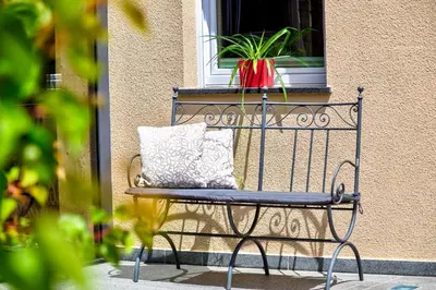 a bench sitting in front of a window with a plant at Residence Engel in Nova Levante