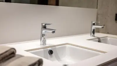 a bathroom sink with two faucets on a counter at Olivia in Tirolo