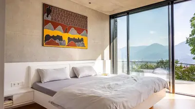 a bedroom with a bed and a large window at Olivia in Tirolo