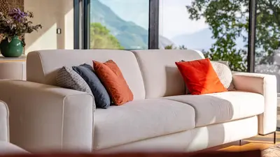 a white couch with pillows on it in front of a window at Olivia in Tirolo