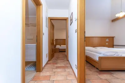 a bedroom with a bed and a mirror at Appartamento Monzoni in Pozza di Fassa