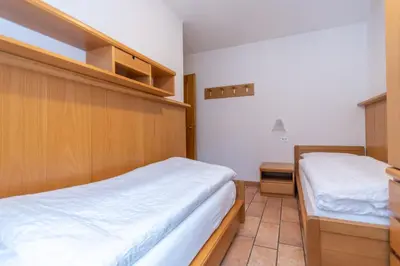 a bedroom with two beds in a room at Appartamento Monzoni in Pozza di Fassa
