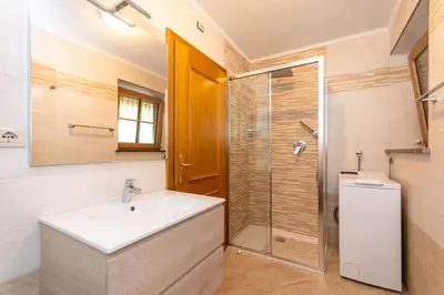 a bathroom with a sink and a shower at Appartamento Monzoni in Pozza di Fassa