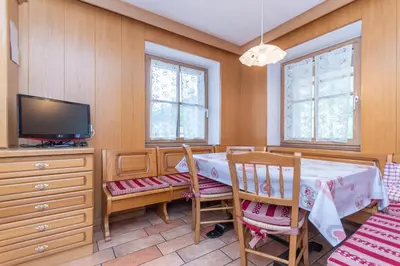 a dining room with a table and a tv at Appartamento Monzoni in Pozza di Fassa