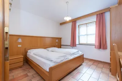 a bedroom with a bed and a window at Appartamento Monzoni in Pozza di Fassa